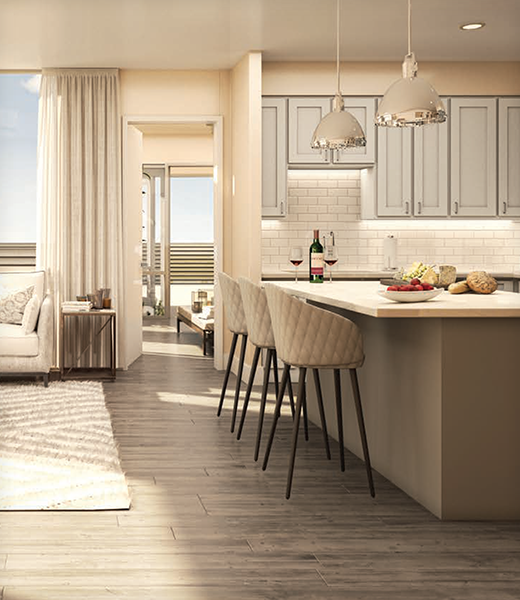 Modern kitchen with white cabinets, island with stools, pendant lights, open living area, and balcony view. Wine and snacks on the counter.