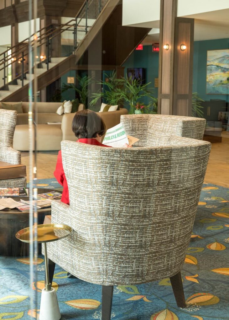 senior woman reads the news while waiting in the 501's lobby